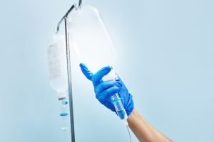 nurse's hand preparing an intravenous drip